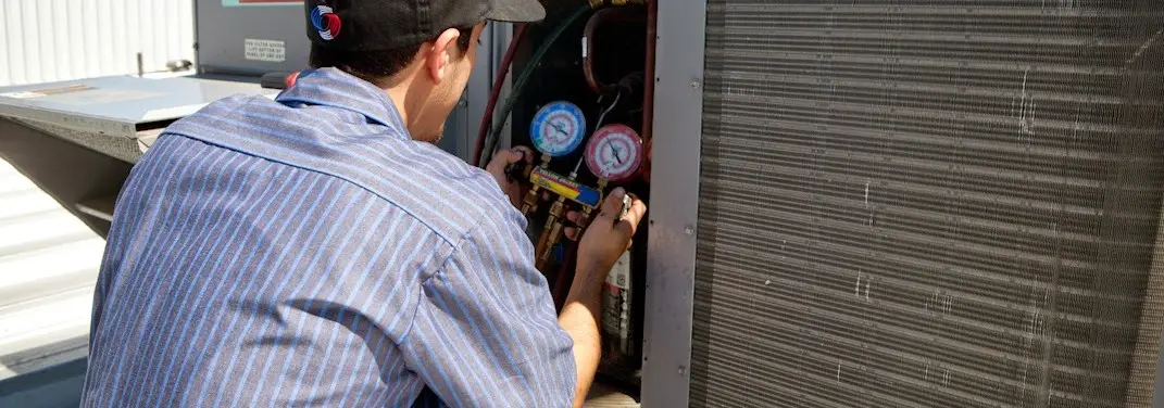 HVAC technician servicing a condenser unit in Ferndale